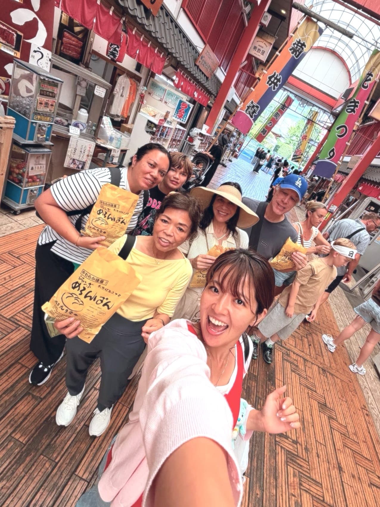 a guide's selfie with her group in a covered market arcade