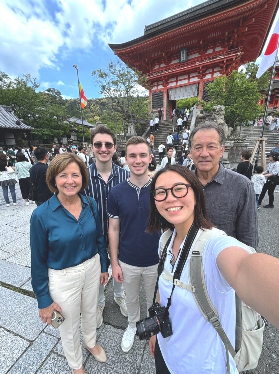 a guide and her four guests smiling in front of a temple gate