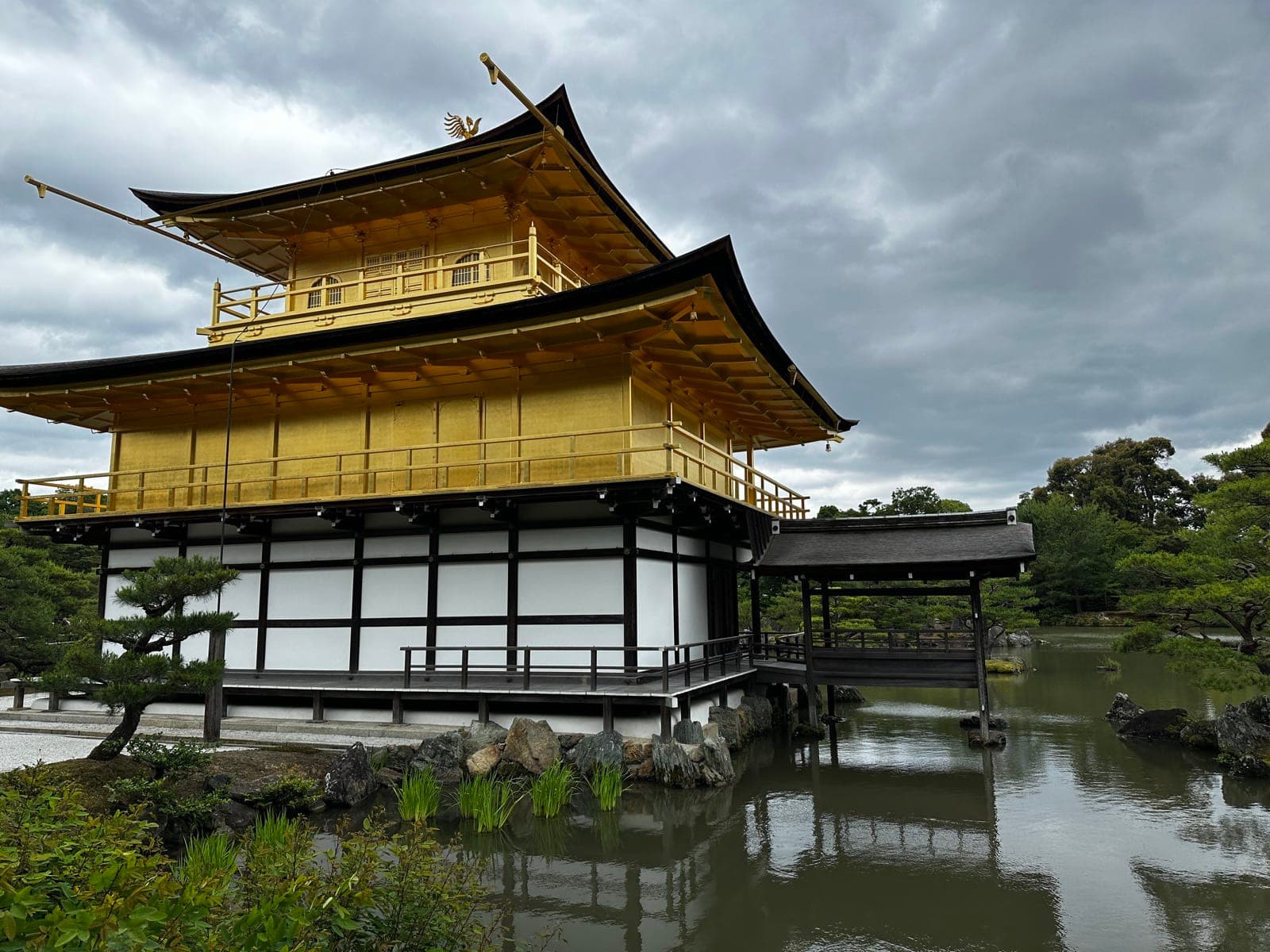 the Golden Pavilion reflected in its still pond under a grey sky, nobody in frame