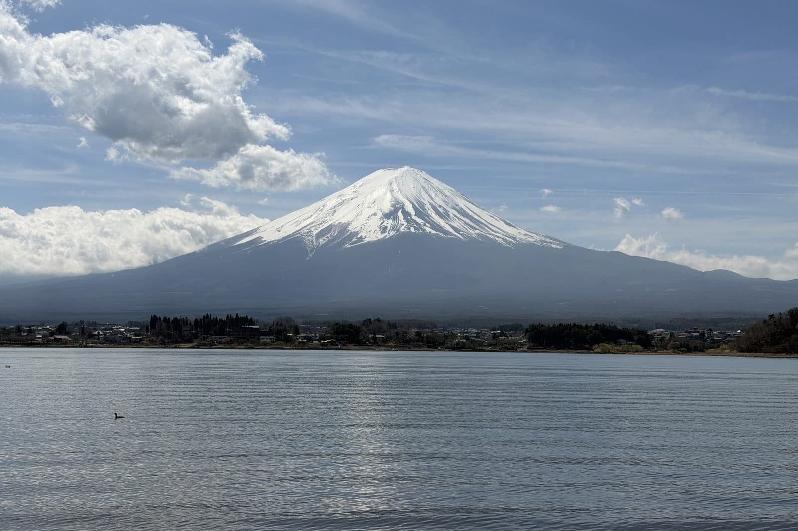 snow-capped Mount Fuji across the lake, cloud banked to one side