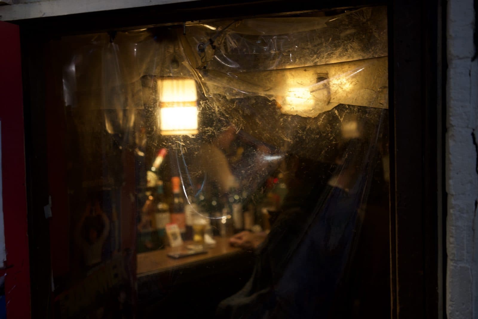 a warm window glowing in a night alley