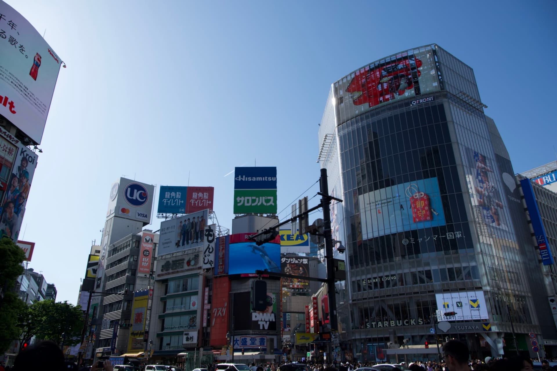 Shibuya's stacked signs above the crossing on a clear day